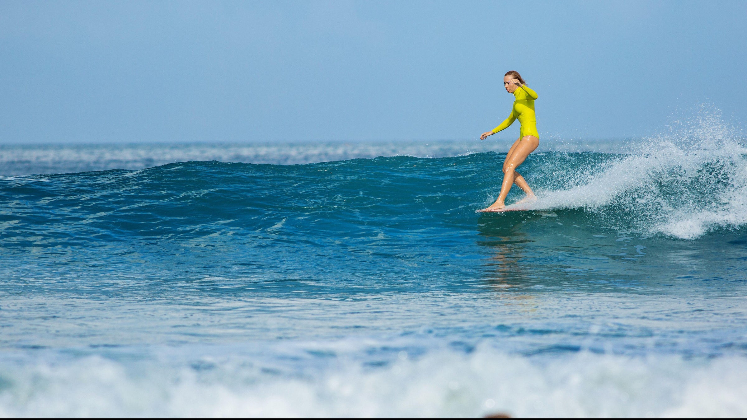 A longboarder walking to the nose on a clean wave